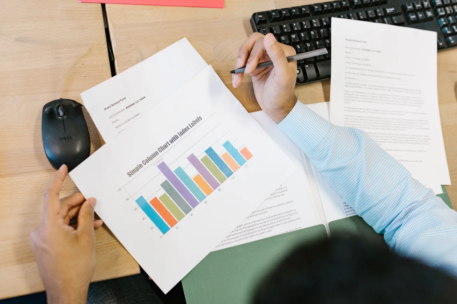 A business analyst reviews a colorful bar chart and documents at a desk, indicating data analysis. How to measure SEO analytics with defined populations and defensible baselines