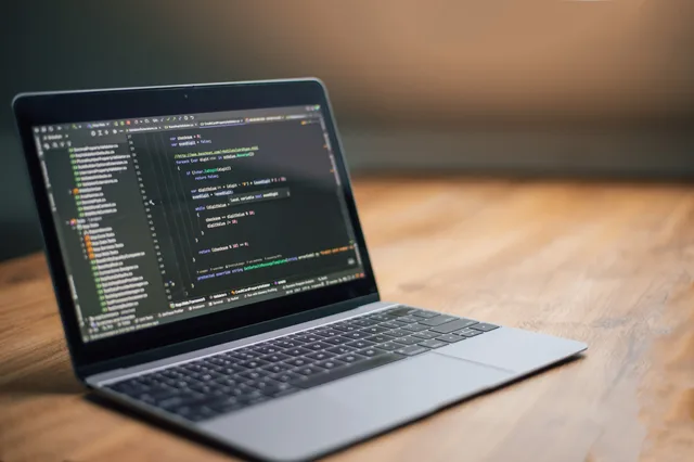Laptop displaying software code on a wooden table, ideal for tech and programming themes. On page SEO benchmarks: fixed thresholds vs cohort baselines