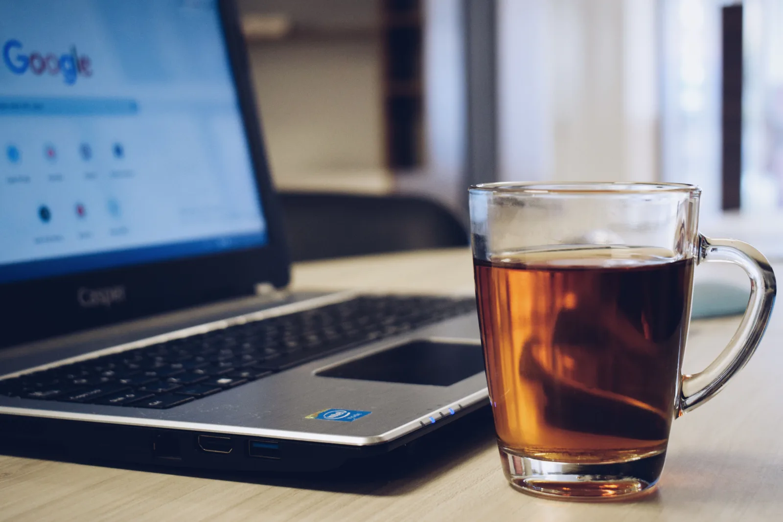 A comforting workspace featuring a laptop and a hot glass of tea on a wooden desk. SEO strategy framework: business decisions, operating cadence, and measurement