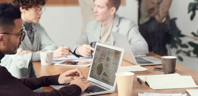 Professionals collaborating in an office setting, focused on digital data analysis during a meeting. A realistic take on SEO strategy best practices in 2027