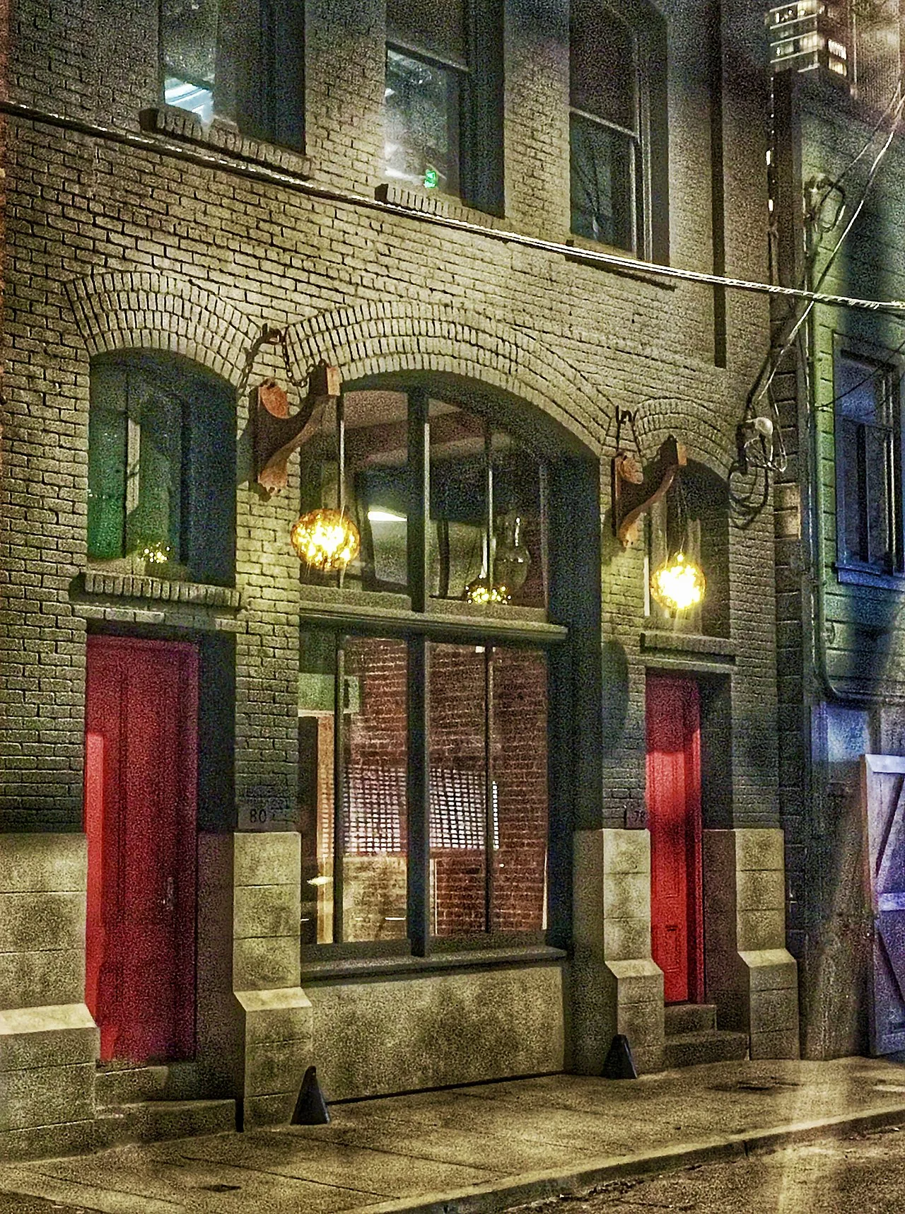 An illuminated storefront on a wet street in San Francisco at night.